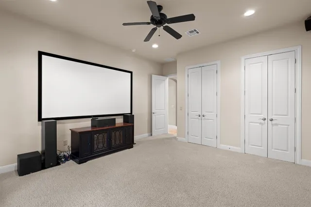 an empty room with chandelier fan and windows