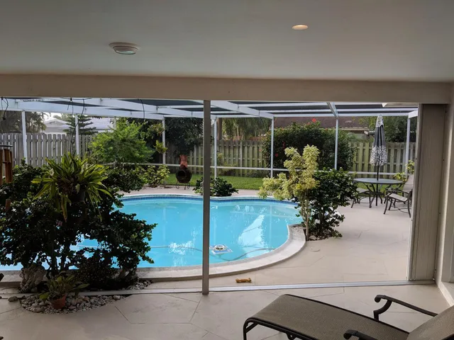 a room with lots of potted plants and a large window