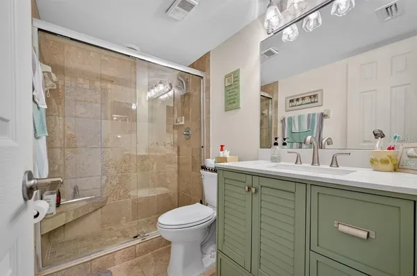 a bathroom with a sink a toilet and shower