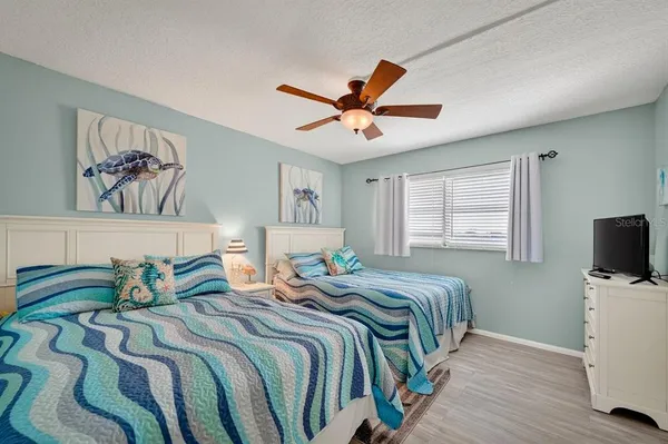 a bedroom with two beds and a chandelier