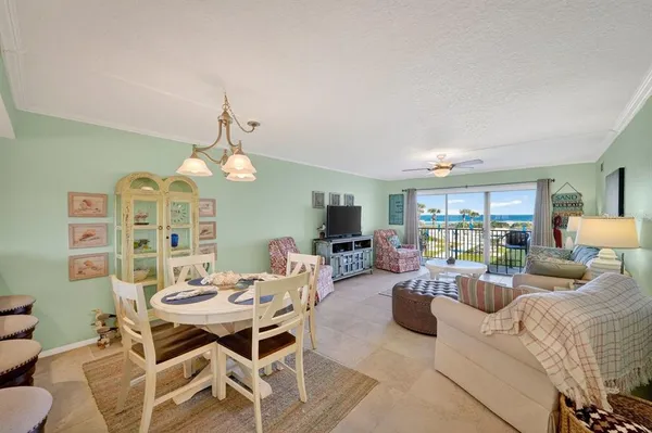 a living room with furniture a chandelier and a dining table