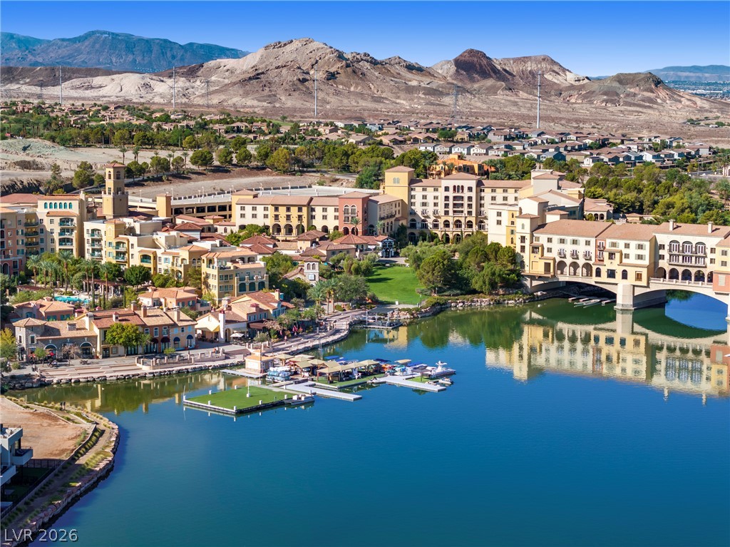 45 Garibaldi Way Henderson, NV 89011 - Photo 69 of 74 A picturesque waterfront village featuring charming architecture and a vibrant marina, all set against a dramatic mountain backdrop.