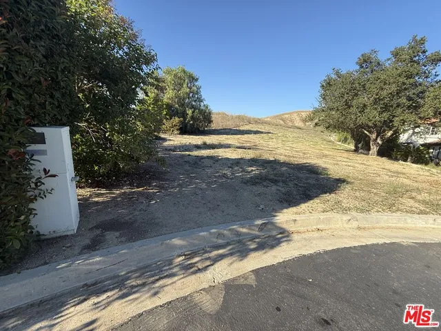 a view of a dry yard with mountains in the background
