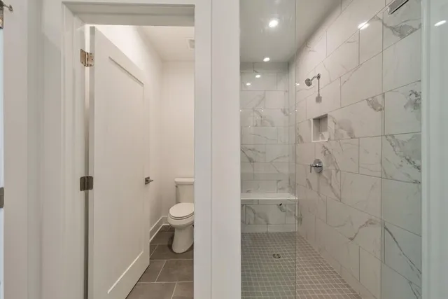 a bathroom with a granite countertop shower and a toilet