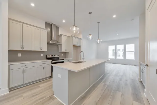 a large kitchen with cabinets wooden floor and a sink