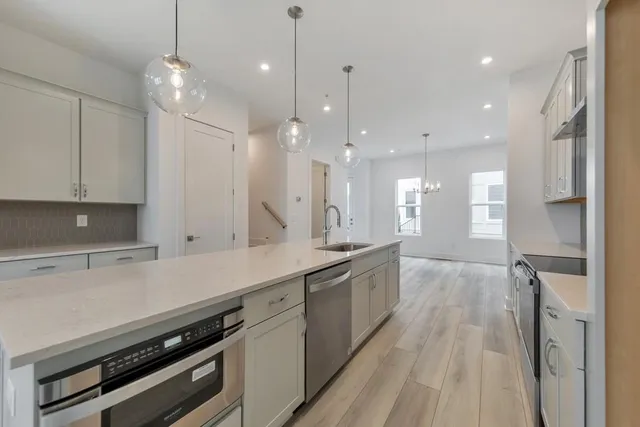 a large kitchen with cabinets a sink and stainless steel appliances