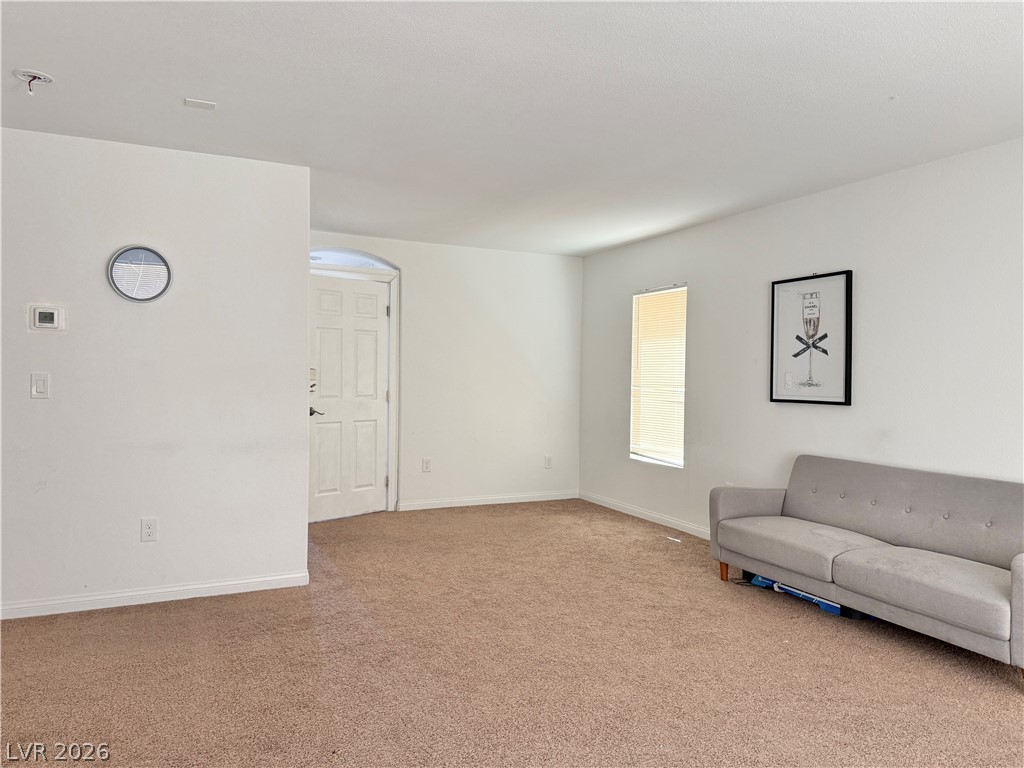 7777 South Westwind Road Las Vegas, NV 89139 - Photo 4 of 46 A welcoming front entry seamlessly transitions into a spacious living area with soft carpeting.