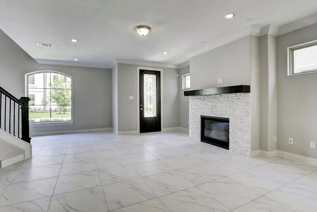a view of an empty room with a fireplace and a window