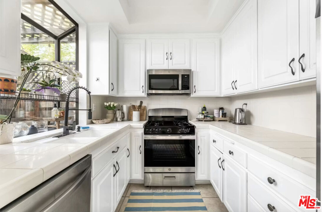1108 18th Street, Unit 5 Santa Monica, CA 90403 - Photo 7 of 11 a kitchen with cabinets stainless steel appliances a sink and a stove