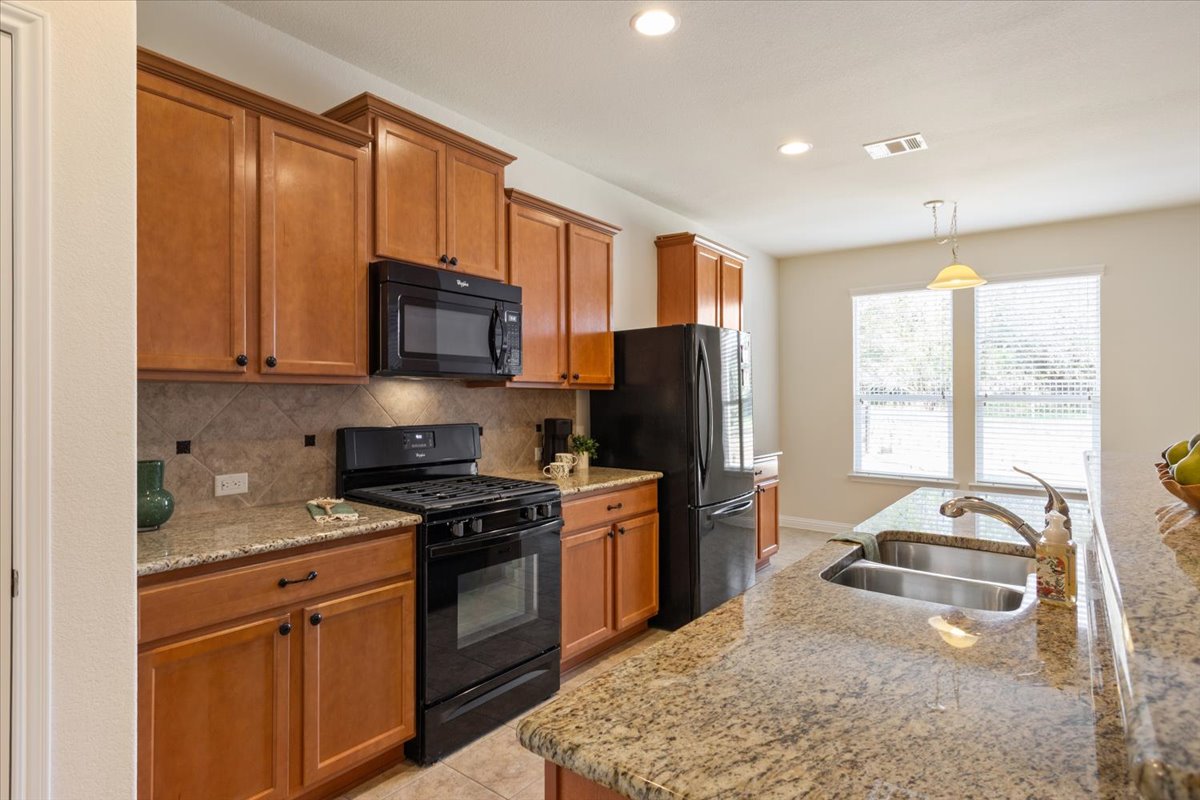 108 Cathedral Mountain Pass Georgetown, TX 78633 - Photo 12 of 36 a kitchen with a stove a sink and a refrigerator