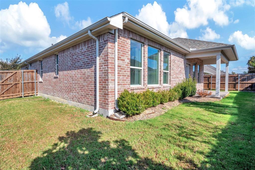 1605 Cedar Crest Drive Forney, TX 75126 - Photo 20 of 26 a view of a brick house with a yard potted plants