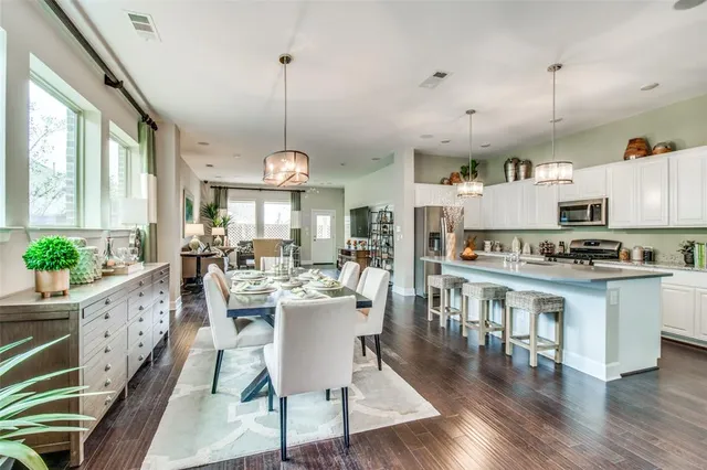 a view of a dining room and livingroom with furniture wooden floor a chandelier