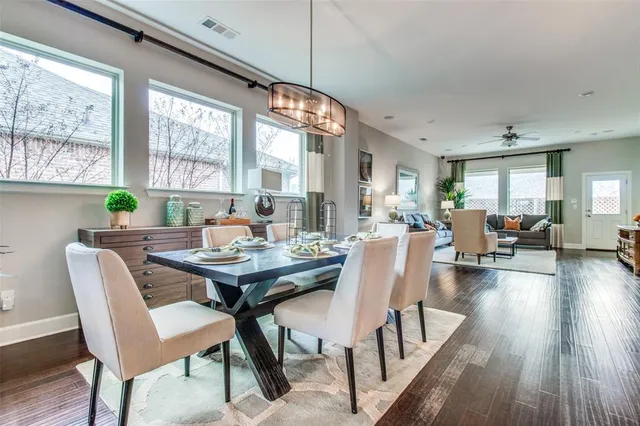 a dining room with furniture a chandelier and wooden floor