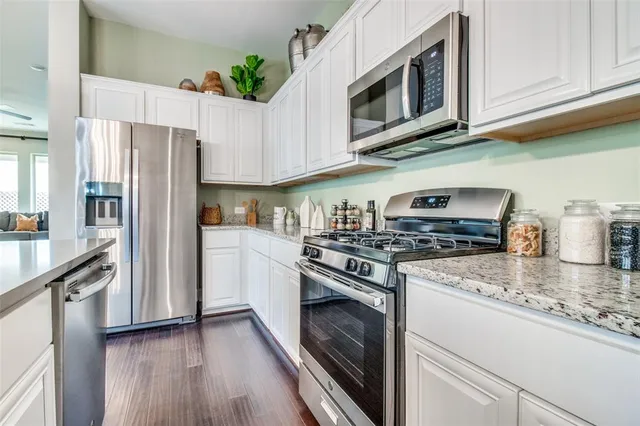 a kitchen with granite countertop wooden cabinets and stainless steel appliances