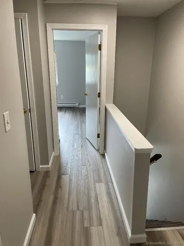 a view of a hallway with wooden floor and staircase
