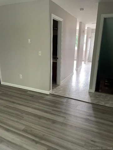 a view of a living room with wooden floor and a flat screen tv