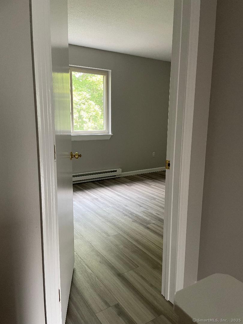 155 Unit 2 Bristol Street Thompson, CT 06277 - Photo 15 of 18 a view of an empty room with wooden floor and a window
