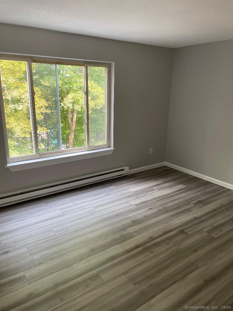 155 Unit 2 Bristol Street Thompson, CT 06277 - Photo 17 of 18 an empty room with wooden floor and windows