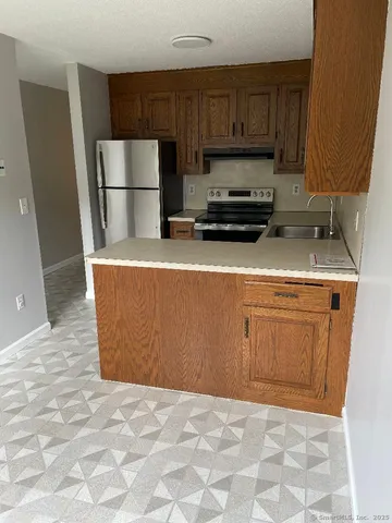 a kitchen with a sink a refrigerator and cabinets