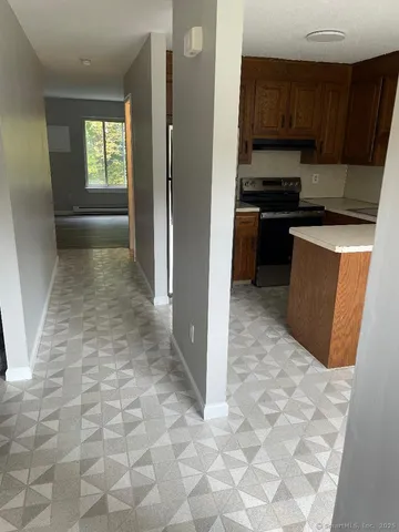 a kitchen with granite countertop a refrigerator and a stove top oven