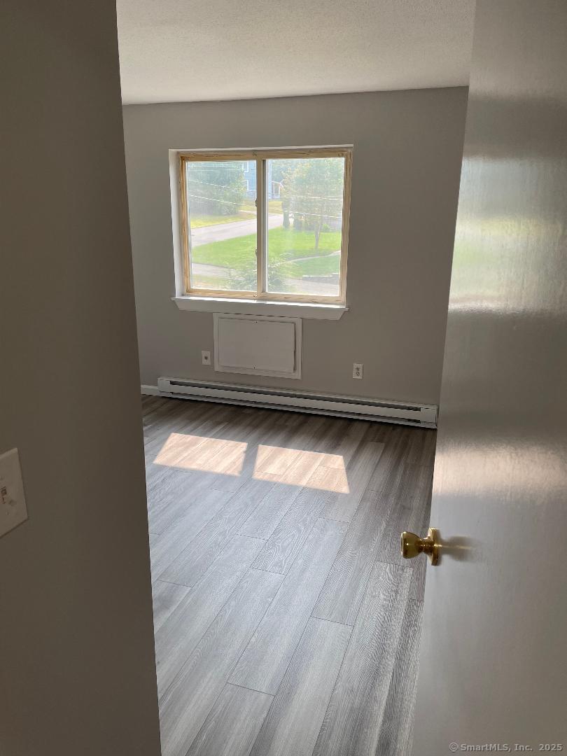 155 Unit 2 Bristol Street Thompson, CT 06277 - Photo 9 of 18 an empty room with wooden floor and windows