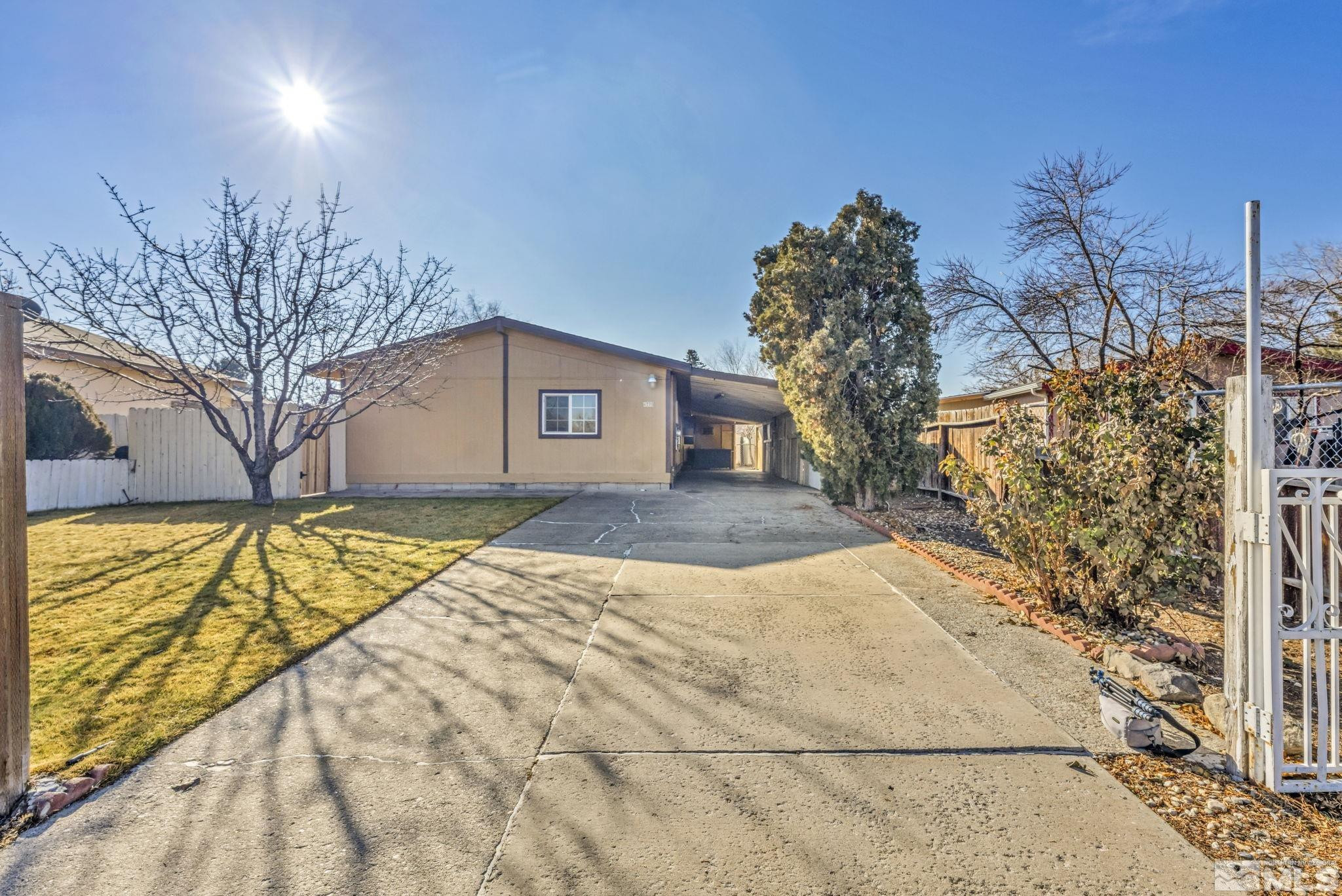 4770 Rampion Way Sun Valley, NV 89433 - Photo 2 of 17 a view of yellow house with a yard and potted plants
