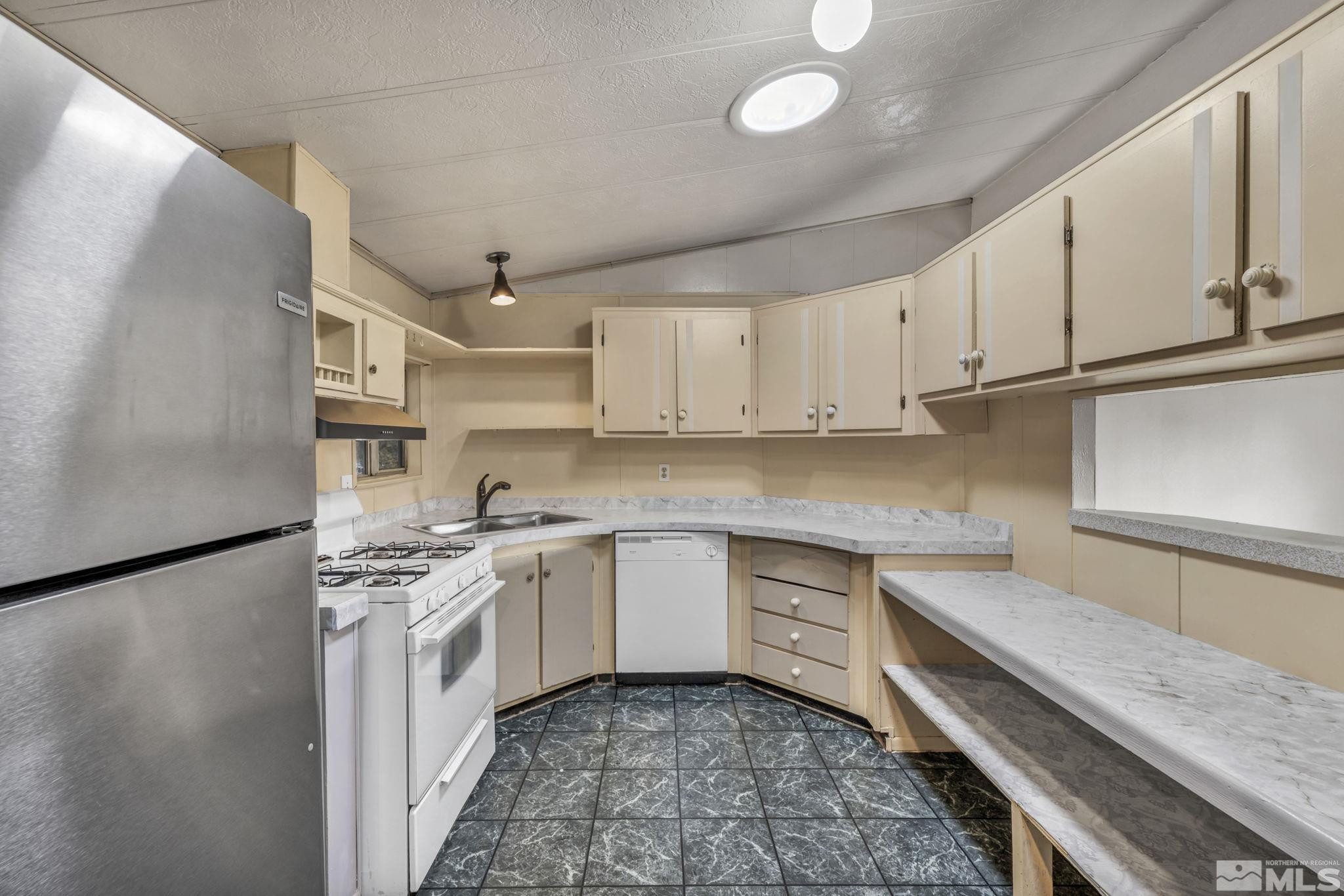4770 Rampion Way Sun Valley, NV 89433 - Photo 6 of 17 a kitchen with stainless steel appliances granite countertop a sink stove and refrigerator