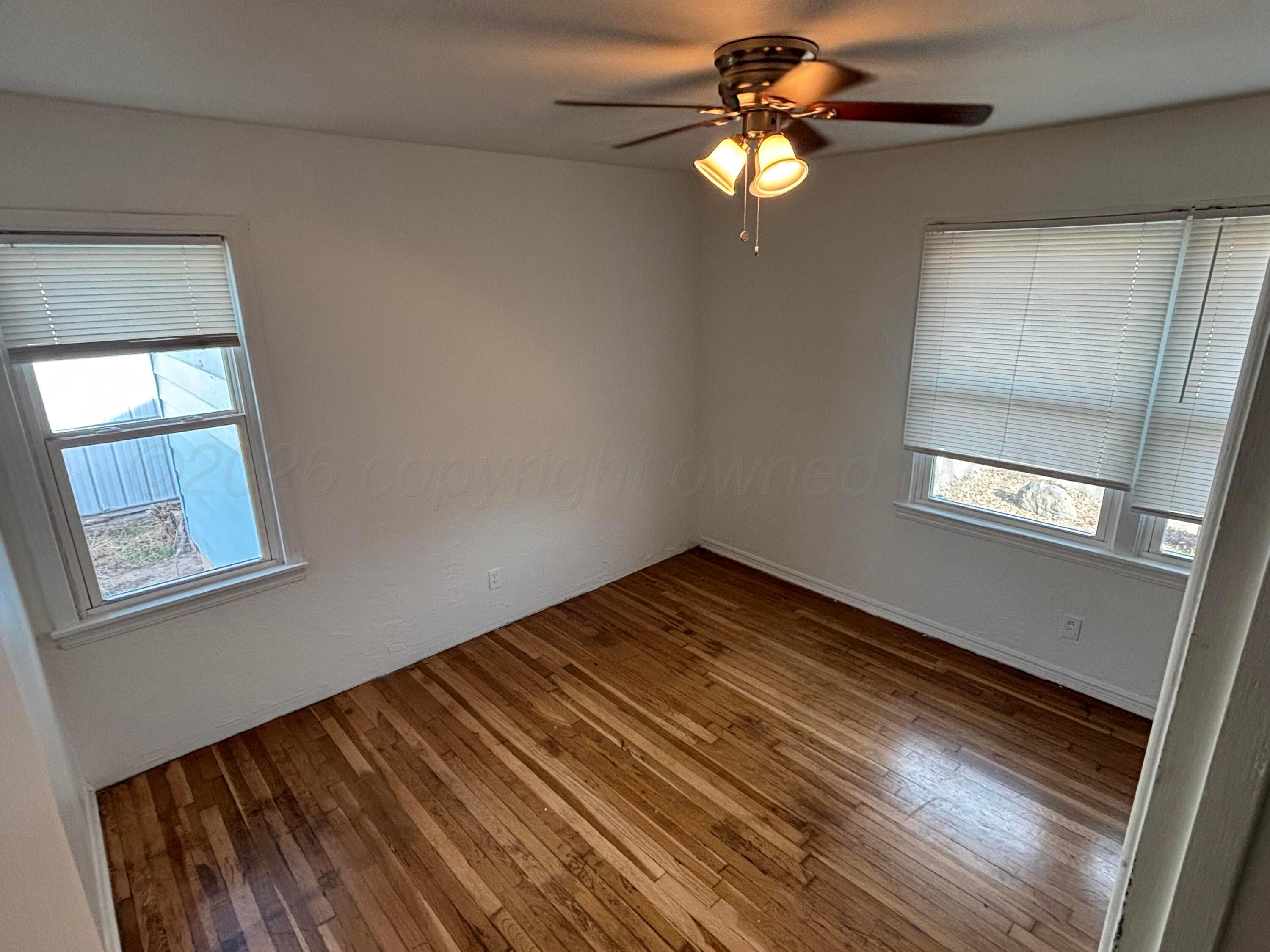 4014 Cline Road Amarillo, TX 79110 - Photo 12 of 21 a view of empty room with window and wooden floor