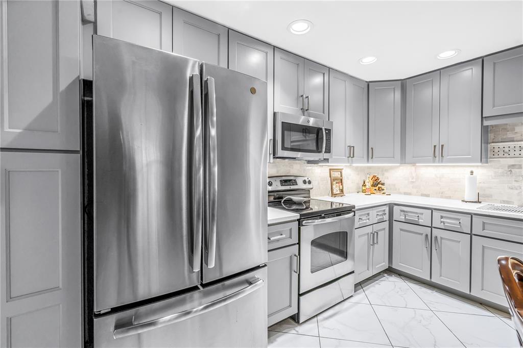 415 Spring Lakes Boulevard, Unit 415D Bradenton, FL 34210 - Photo 11 of 52 a kitchen with stainless steel appliances a refrigerator sink and microwave