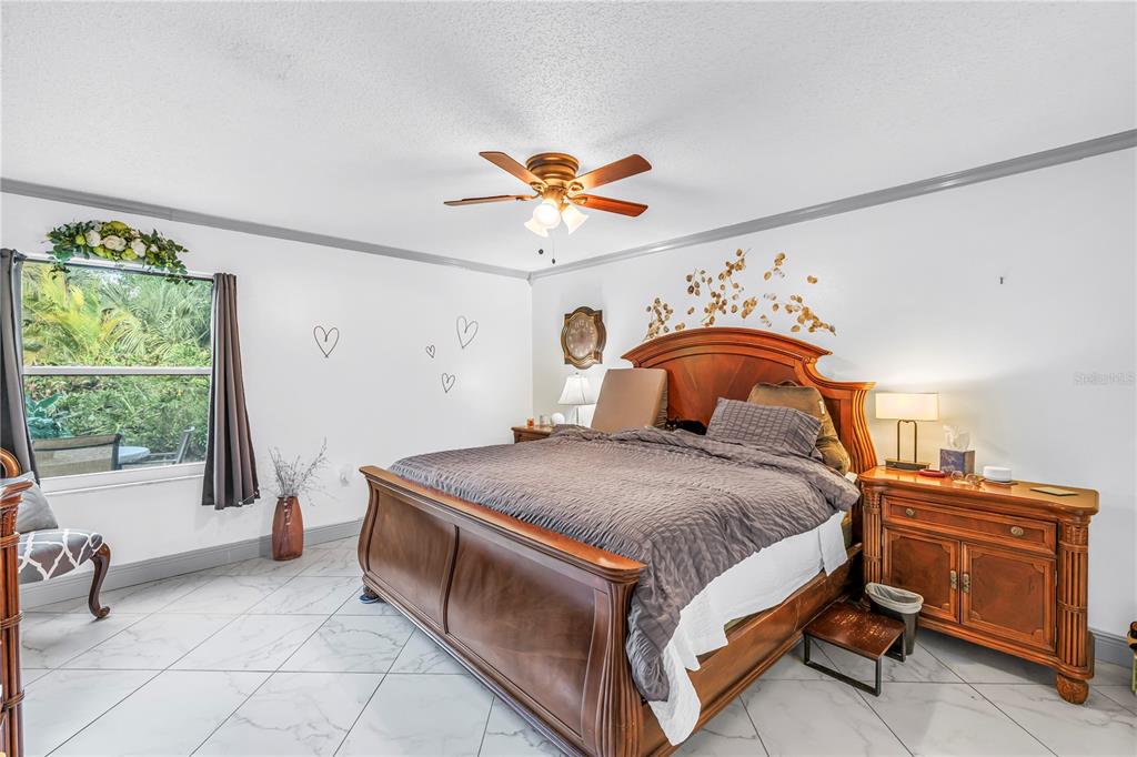 415 Spring Lakes Boulevard, Unit 415D Bradenton, FL 34210 - Photo 18 of 52 a spacious bedroom with a bed and a table in it
