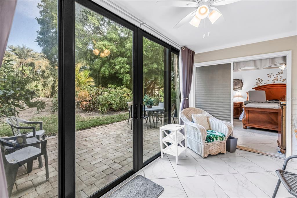 415 Spring Lakes Boulevard, Unit 415D Bradenton, FL 34210 - Photo 27 of 52 a living room with patio furniture and a floor to ceiling window