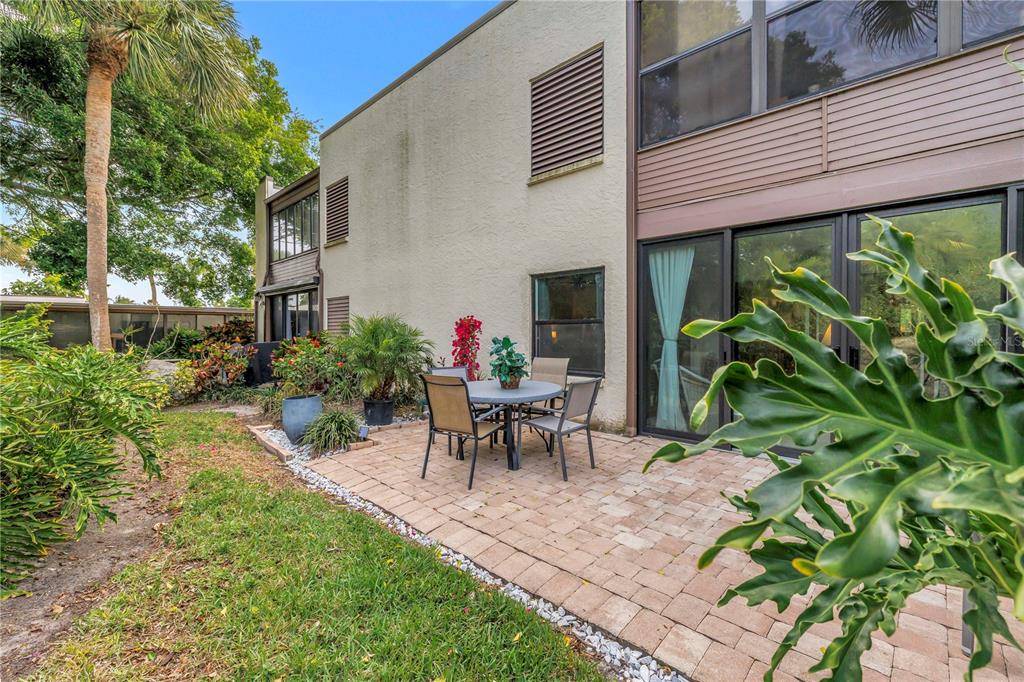 415 Spring Lakes Boulevard, Unit 415D Bradenton, FL 34210 - Photo 36 of 52 a view of a patio with table and chairs potted plants and floor to ceiling window and wooden fence