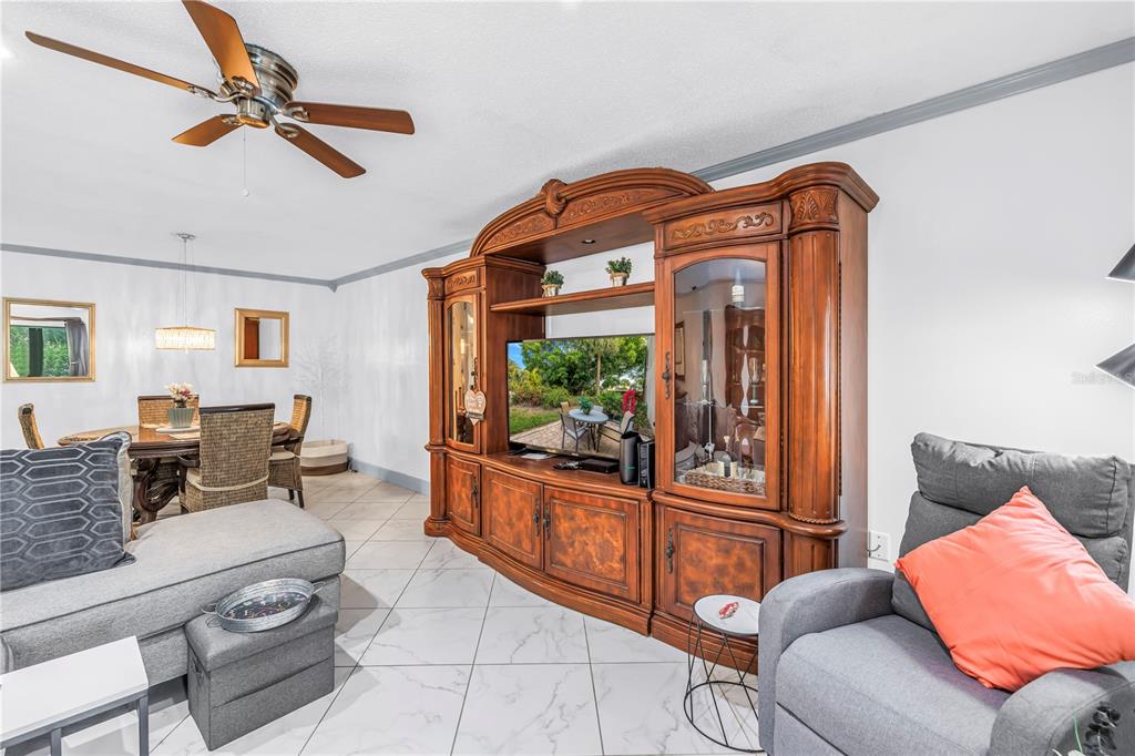 415 Spring Lakes Boulevard, Unit 415D Bradenton, FL 34210 - Photo 6 of 52 a living room with furniture and a flat screen tv