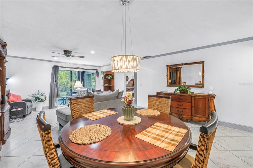 415 Spring Lakes Boulevard, Unit 415D Bradenton, FL 34210 - Photo 7 of 52 a dining room with furniture a chandelier and window