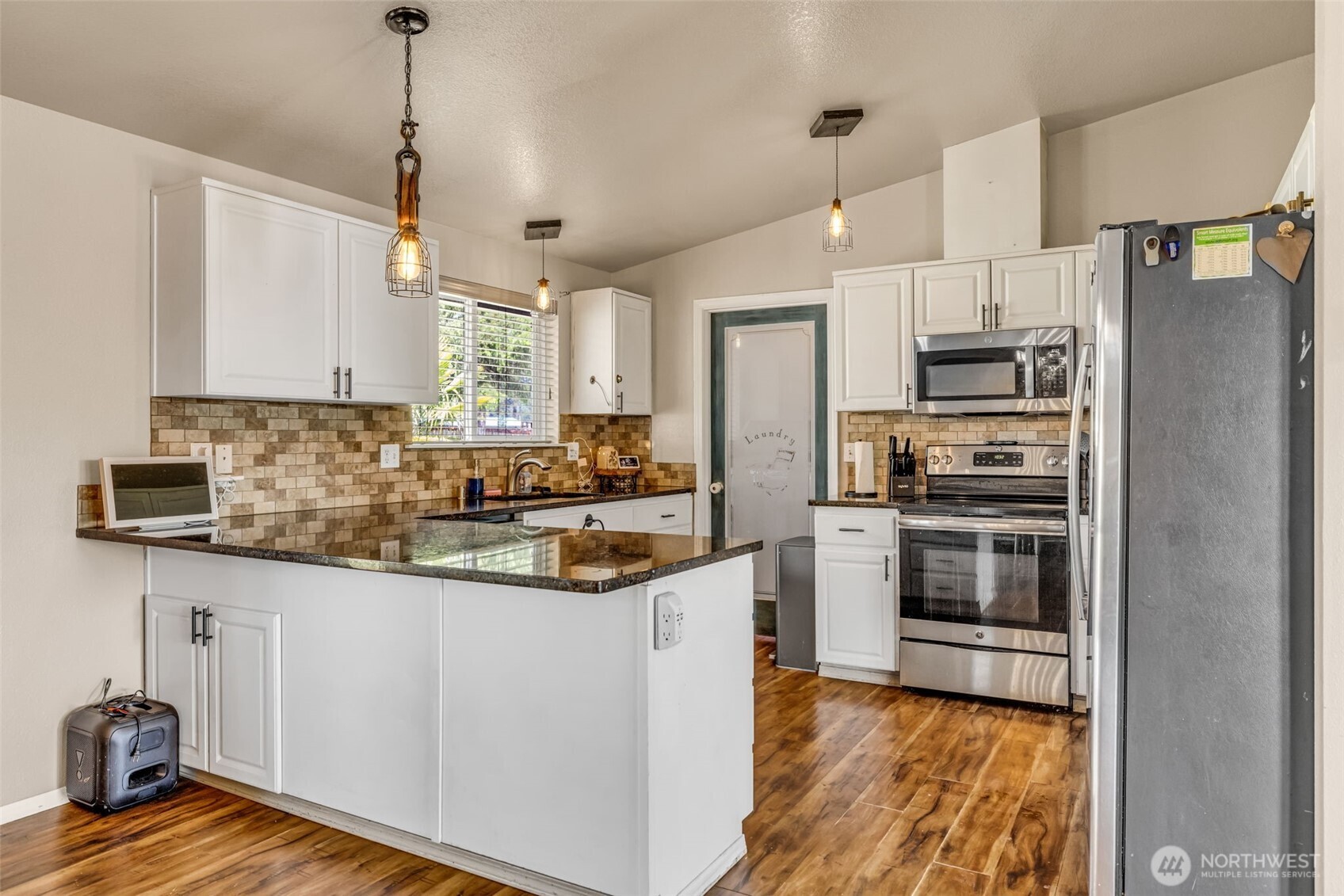 10313 School Land Road Southwest Rochester, WA 98579 - Photo 12 of 40 a kitchen with stainless steel appliances a stove a sink a refrigerator and a microwave