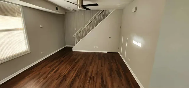 a view of a hallway with wooden floor and staircase