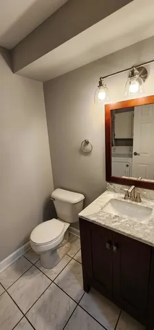 a bathroom with a granite countertop toilet sink and mirror