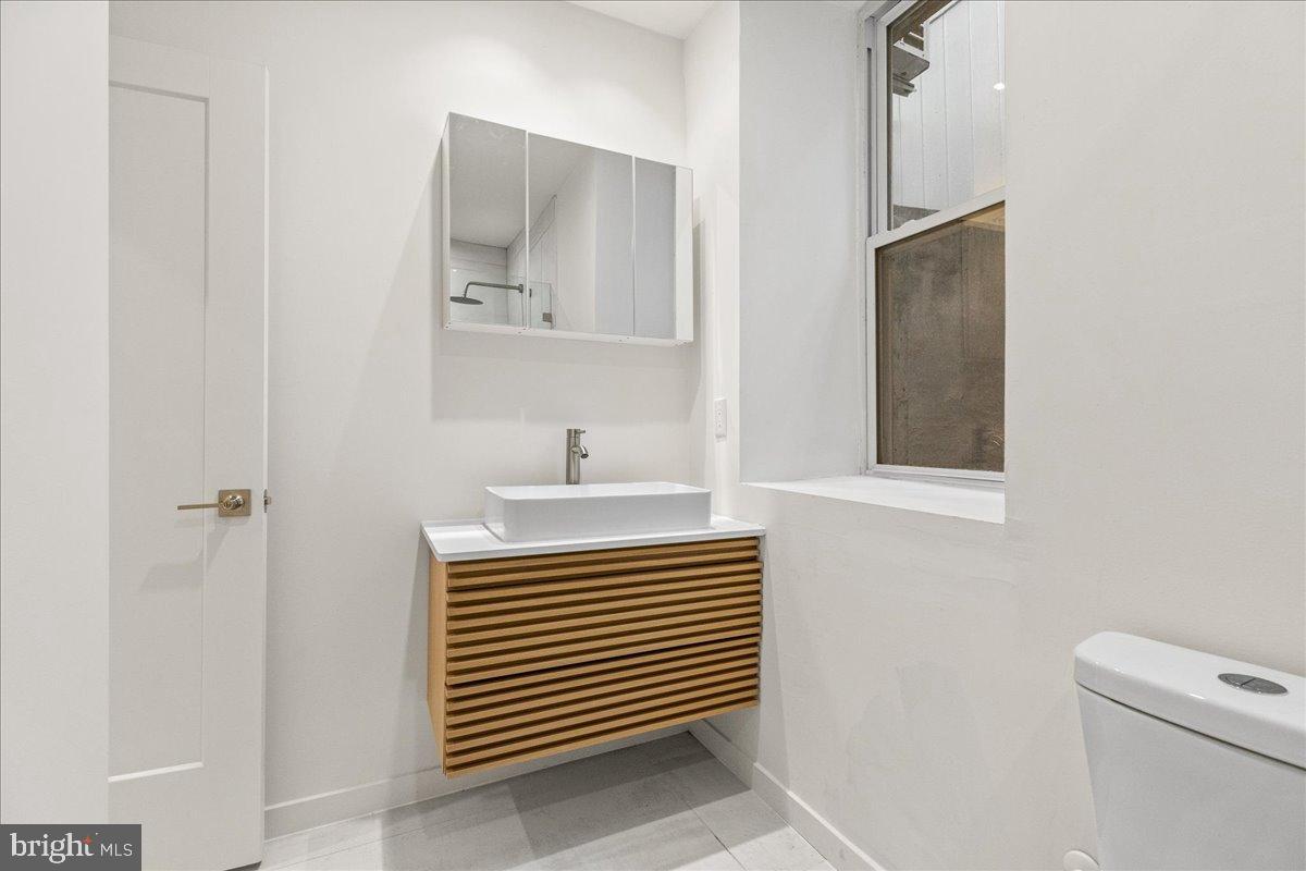 3907 Spring Garden Street, Unit 1 Philadelphia, PA 19104 - Photo 13 of 33 a bathroom with a sink a toilet and mirror