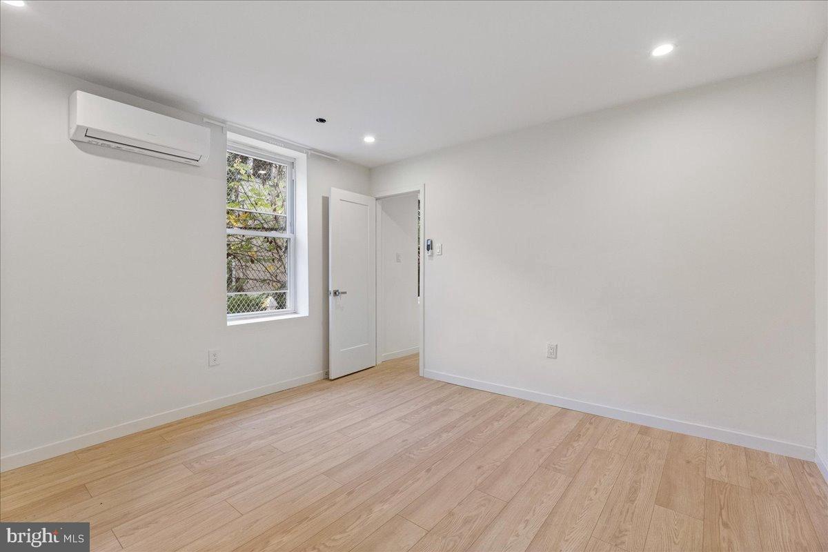 3907 Spring Garden Street, Unit 1 Philadelphia, PA 19104 - Photo 29 of 33 an empty room with wooden floor and windows