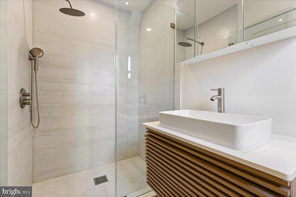 3907 Spring Garden Street, Unit 1 Philadelphia, PA 19104 - Photo 31 of 33 a bathroom with a sink a shower and a mirror