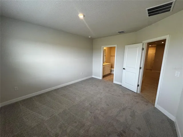 an empty room with closet and mirror