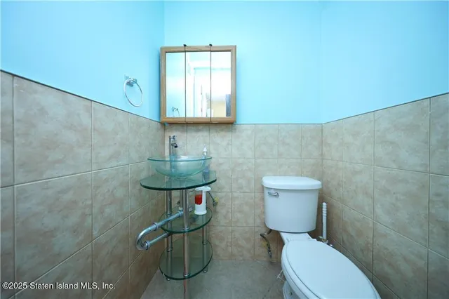 a bathroom with a toilet a sink and mirror