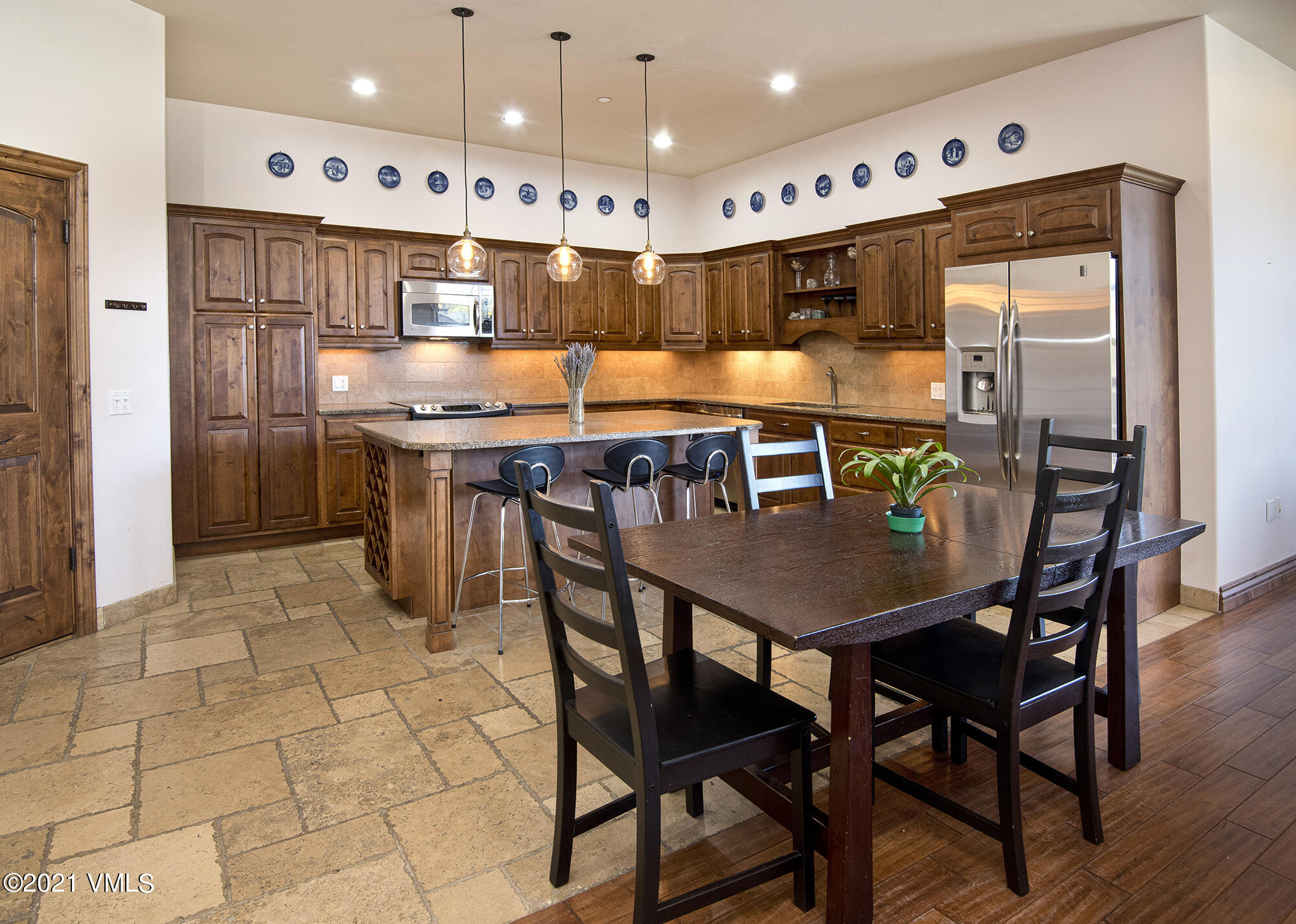 295 Main Street, Unit R201 Edwards, CO 81632 - Photo 4 of 36 a kitchen with stainless steel appliances kitchen island granite countertop a table chairs and a refrigerator