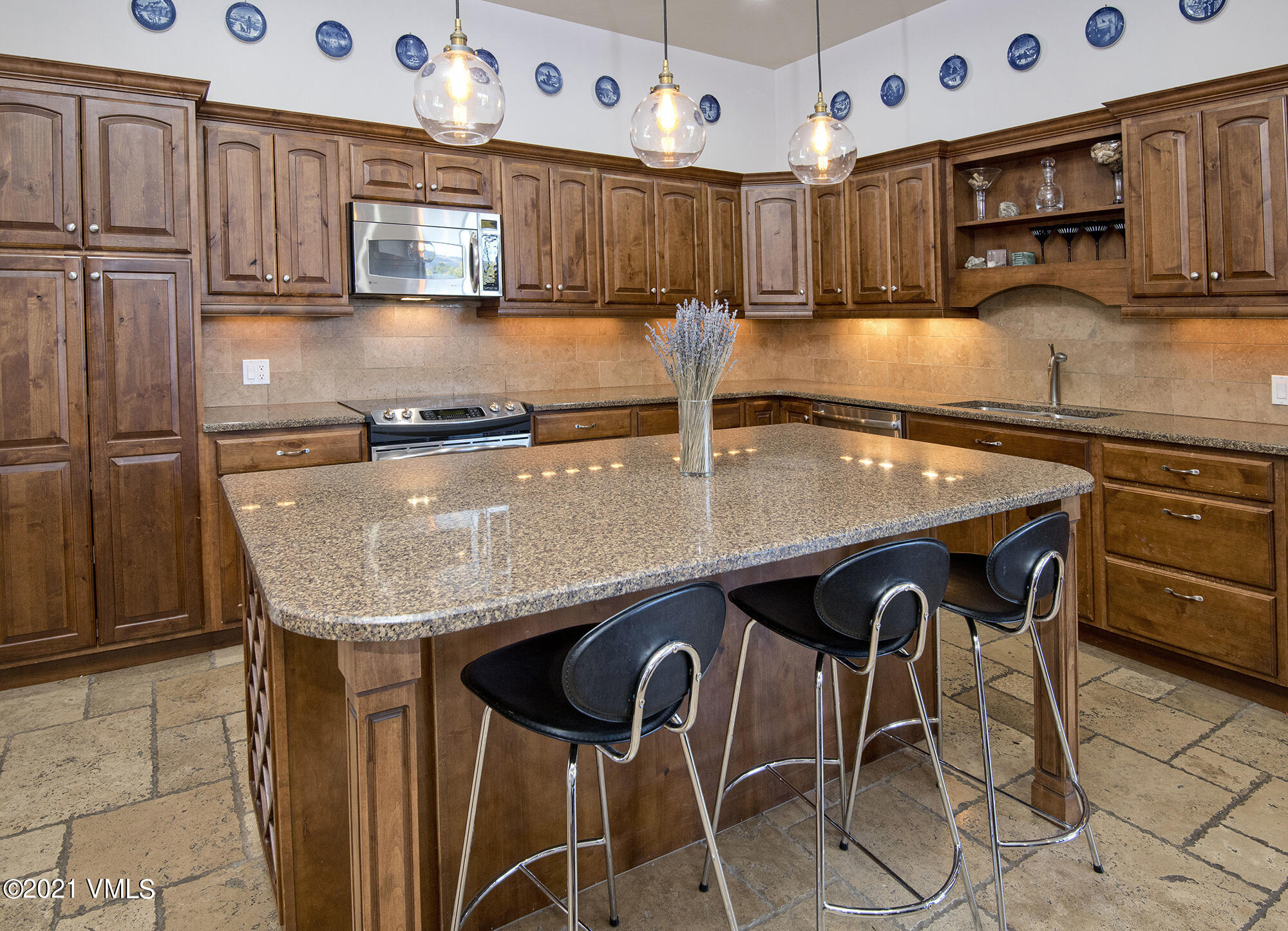 295 Main Street, Unit R201 Edwards, CO 81632 - Photo 5 of 36 a kitchen with granite countertop a table chairs stove and cabinets