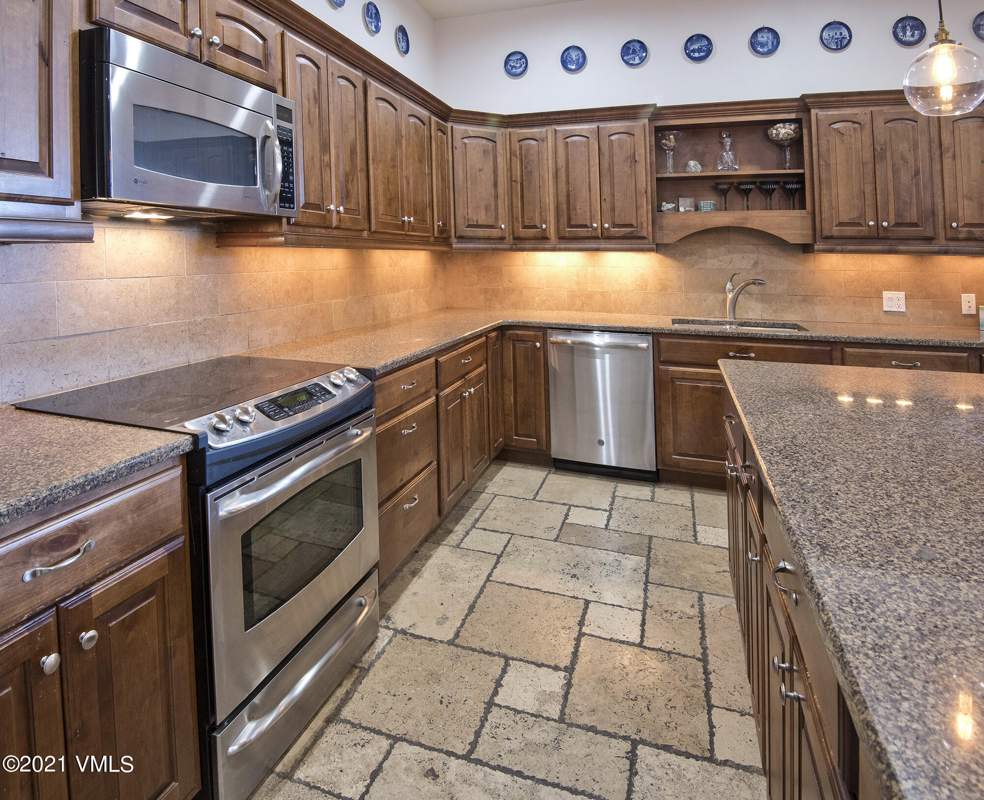 295 Main Street, Unit R201 Edwards, CO 81632 - Photo 6 of 36 a kitchen with stainless steel appliances granite countertop a stove a sink and a microwave