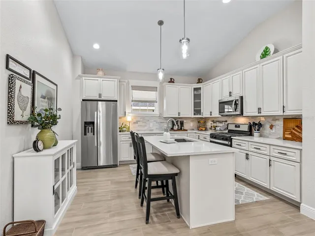 a kitchen with white cabinets and stainless steel appliances