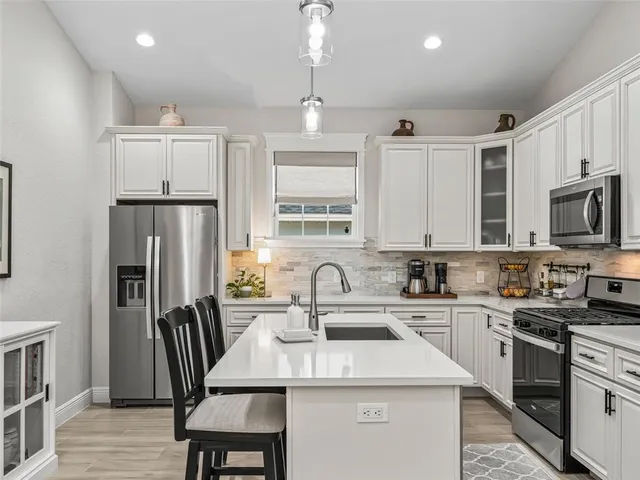 a kitchen with a stove a sink a dining table and chairs