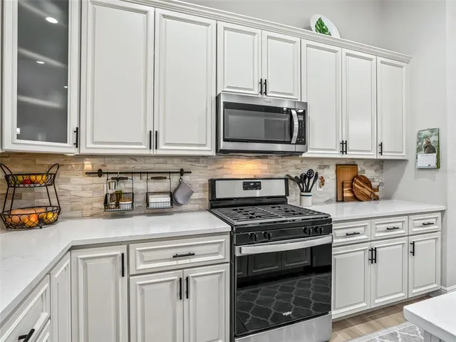 a kitchen with stainless steel appliances white cabinets and a window