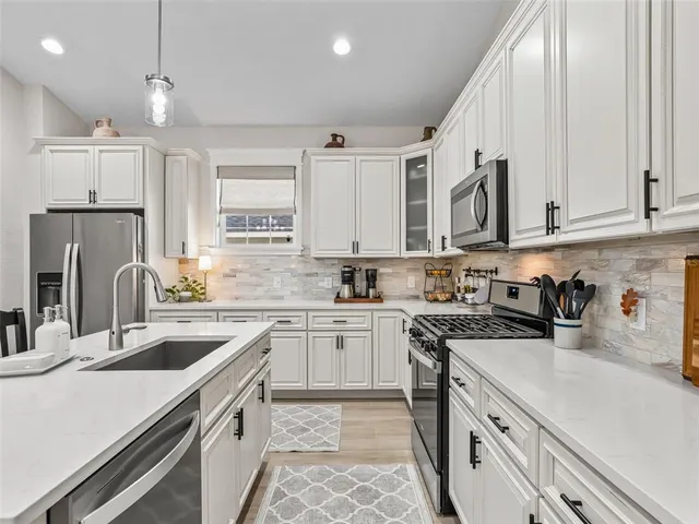 a kitchen with granite countertop a sink stove and cabinets