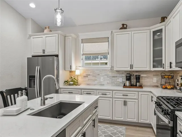 a open kitchen with stainless steel appliances kitchen island a table chairs and a refrigerator